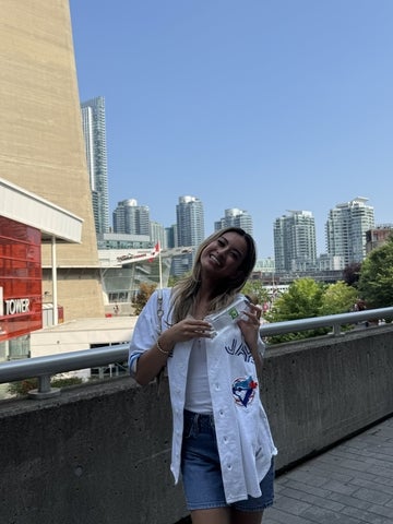 Breanna Levy smiling in Toronto with a Blue Jays jersey