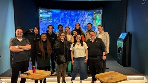 Cameron Stirrup standing in group photo with work team