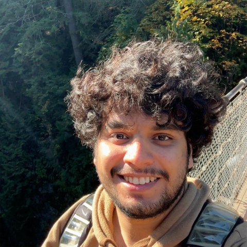 Selfie-style image of Vinayak Bector smiling on a bridge 