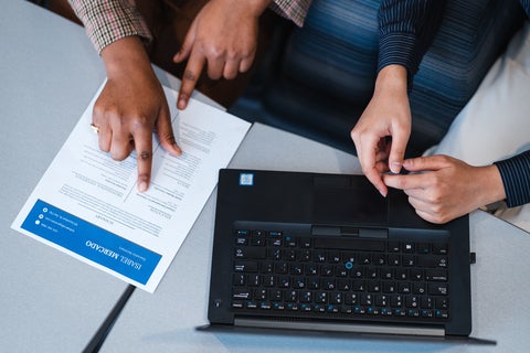 laptop and resume with student pointing 