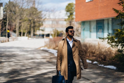 Student walking outside holding a briefcase 