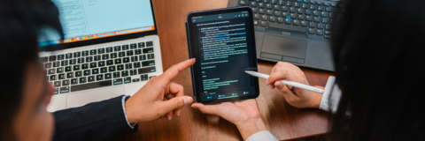 A co-op employer and student looking at an ipad with text