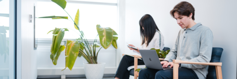 Two students one on a laptop
