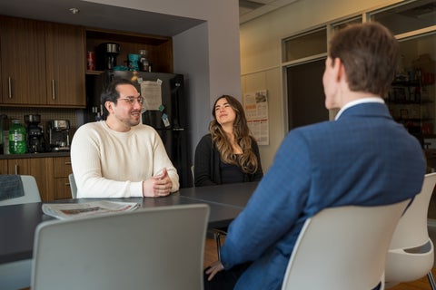 co-op student sitting at table with 2 employees sitting across from them