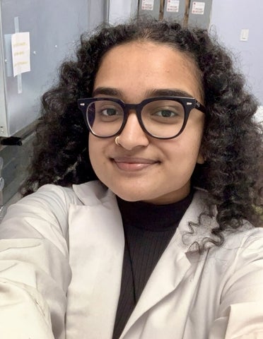 Hamisha Ramesh taking a selfie in a white lab coat