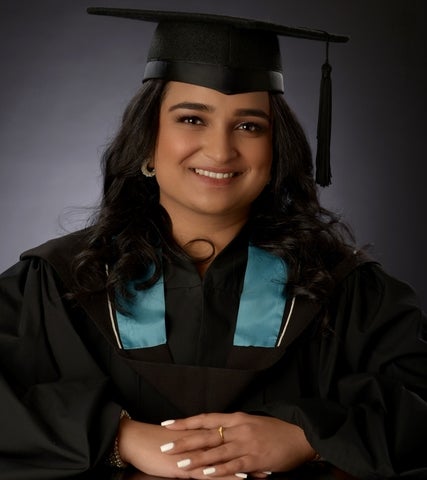 Hamisha Ramesh smiling in a graduation cap and gown
