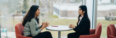 two students sitting across from each other speaking