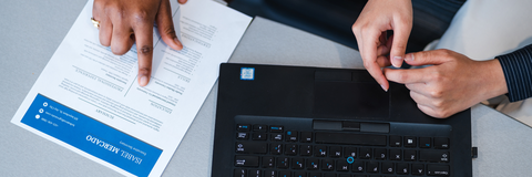laptop and resume with student pointing 