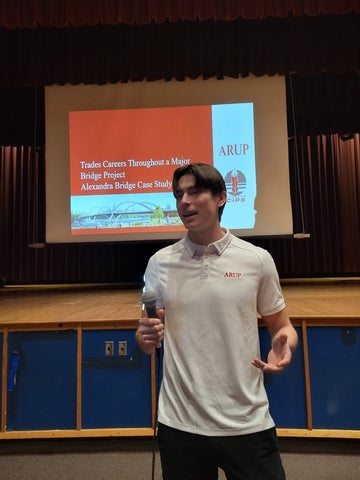 Ethan delivers a presentation while holding a microphone 