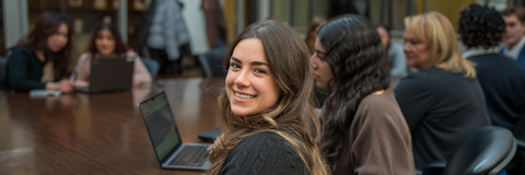 Student in a meeting looking at the camera smiling 