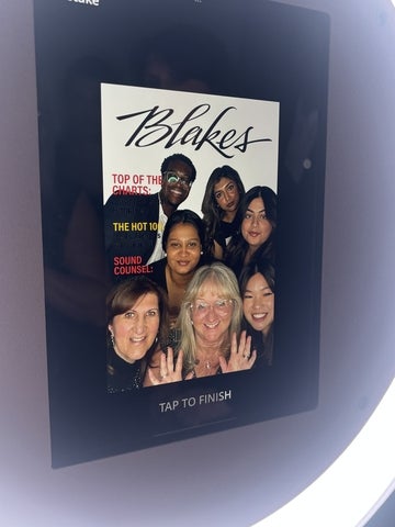 A group of students posing together in a photo booth frame at a Blakes event, smiling for the camera in front of a branded backdrop.