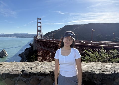 Giang Tran posing in front of a bridge
