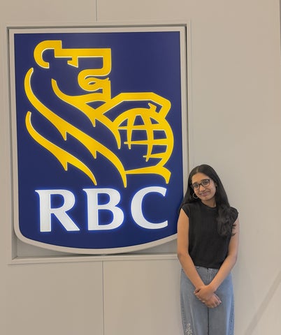 Krithika standing next to the RBC sign at work