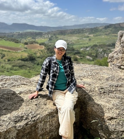 Jane Zeng sitting on rocks