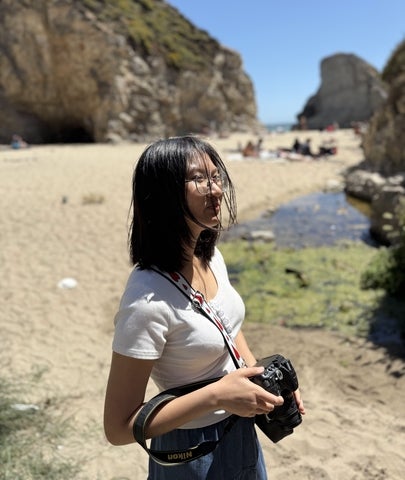 Giang Tran holding a camera outside