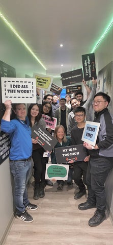 Krithika and coworkers posing for a photo after a group social at an escape room