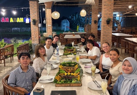 Group of co-op students seated at table with Indonesian cuisine 