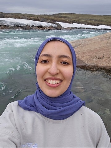 Mariam smiling on a beach