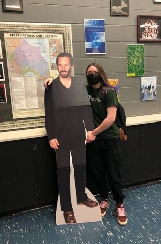 Octavia Andrushko posing with cardboard cutout of Keanu Reeves