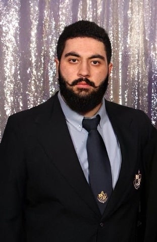 Danial Ghamari standing in a suit