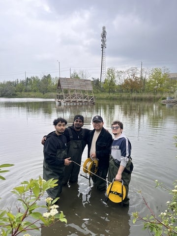 Rafin Khan standing in water with coworkers