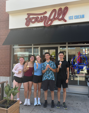 Catherine Mulcaster and other Engineering students posing in front of Four All Ice Cream while holding ice cream