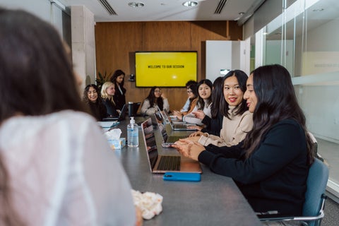students sitting in a meeting room talking to eachother