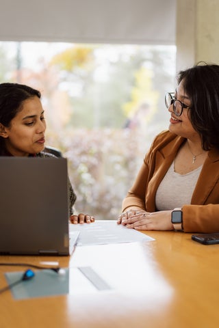 student speaking to advisor at a desk