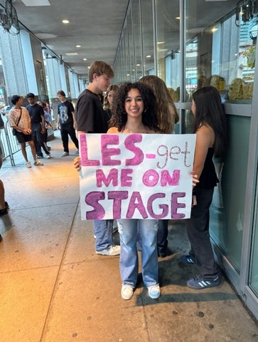 Sarah Bayrakdarian holding a sign reading "les-get me on stage"