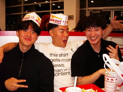 Tobin Tang smiling with friends with In-n-out hats on