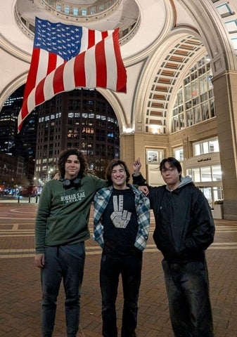 Martin Bissonnette posing with friends in front of an American flag