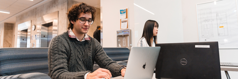 student sitting with laptop in front of him