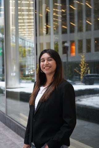 Avni smiling/posing in front of a modern building 