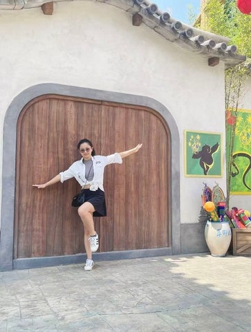 Yunxing Zhang posing outdoors in front of a wooden doorway during co-op abroad