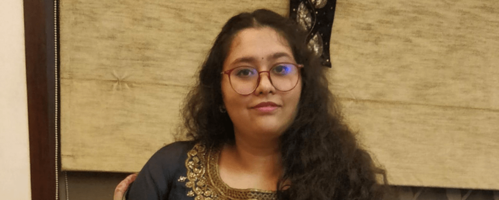 University of Waterloo Math co-op student, Anoushka Gupta, sitting on a chair and smiling