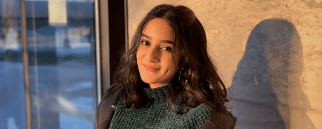 University of Waterloo Arts co-op student, Falak Ismaili, smiling in a building.