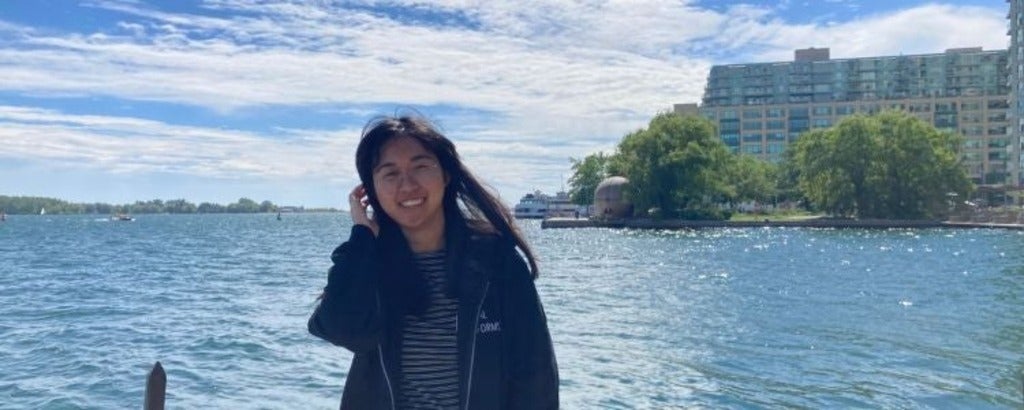 Skylar Ji posing in front of a body of water.