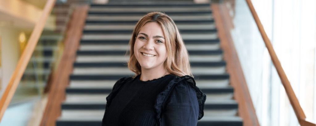 Danielle Lebowitz smiling while standing in front of staircase