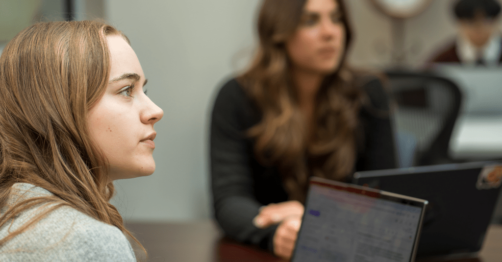 two women sitting with laptops open 