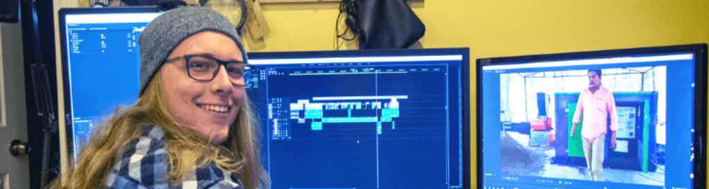 Simon sitting at computer smiling