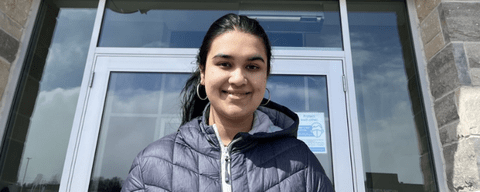 A photo of Sanooba standing in front of the Sun Life Financial building.