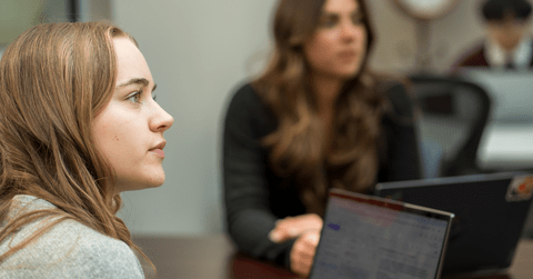 two women sitting with laptops open 