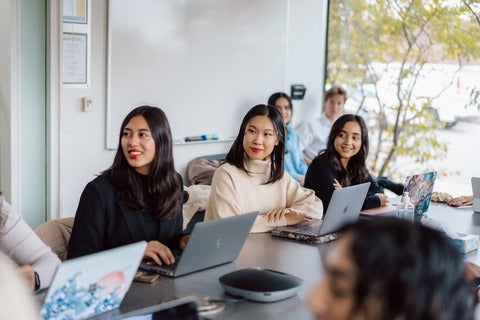 Students in meeting room with laptops