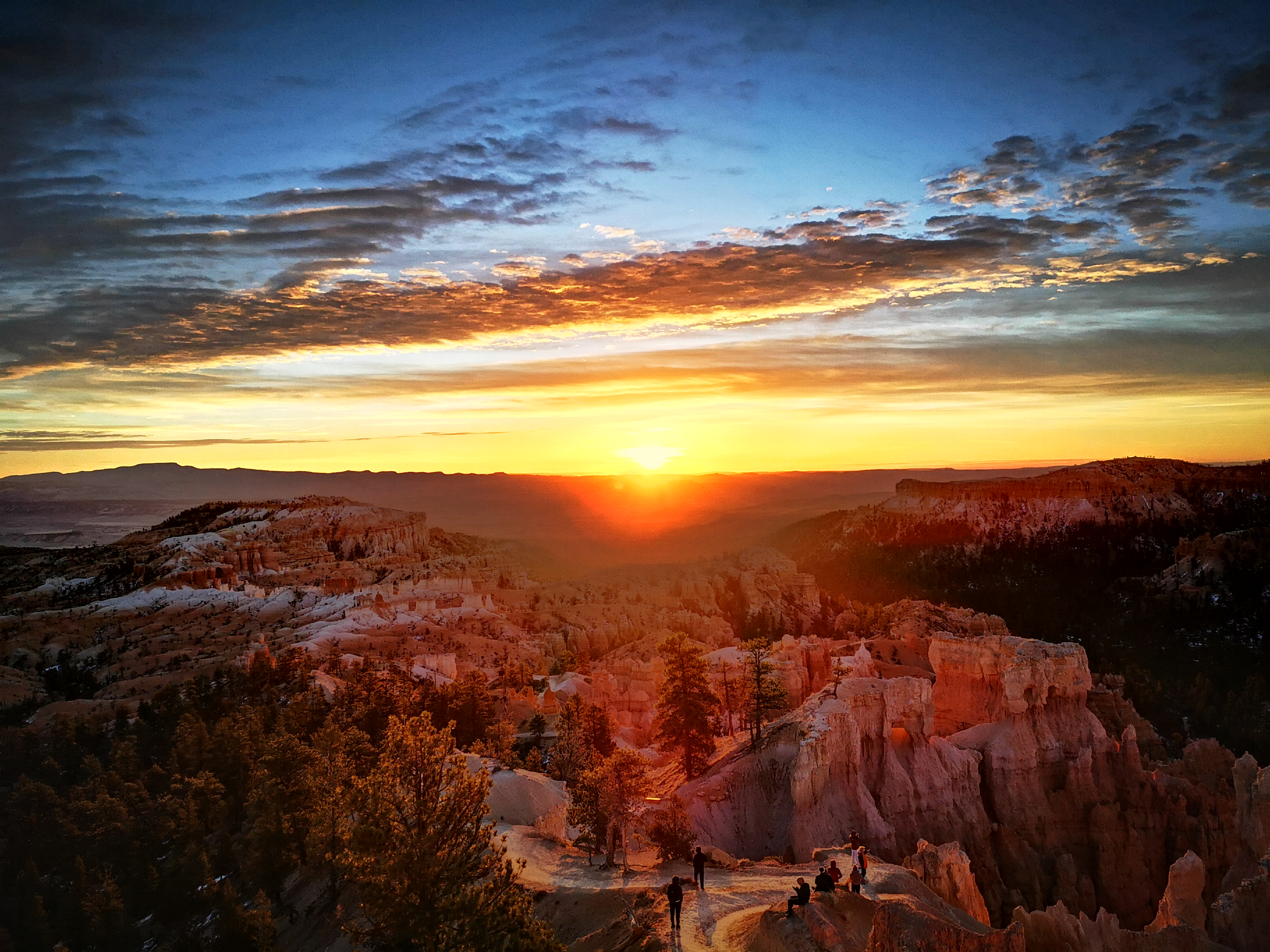 Golden sunset with clouds and red reck mountain landscape below