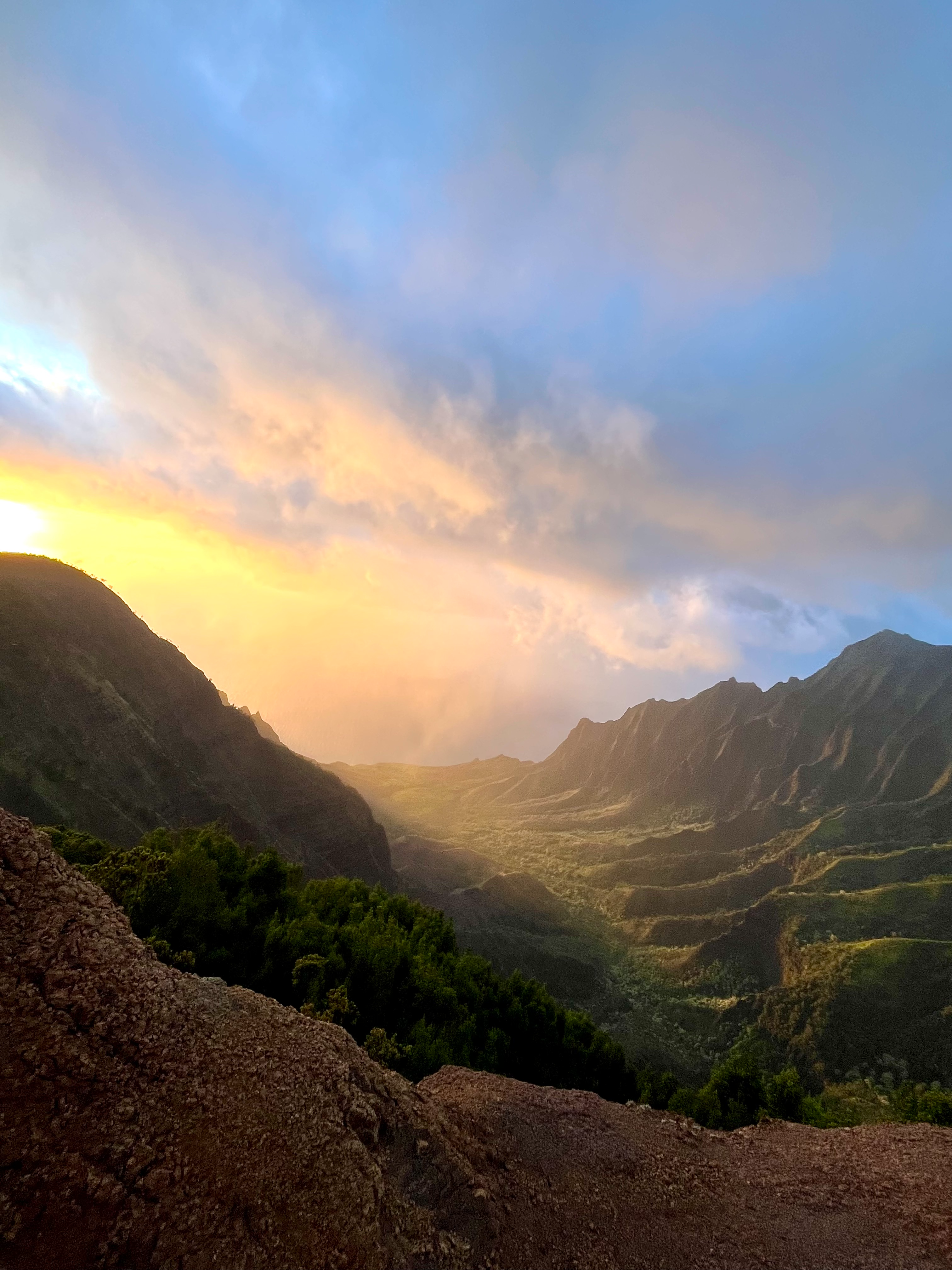 Sun rising over a misty green mountain