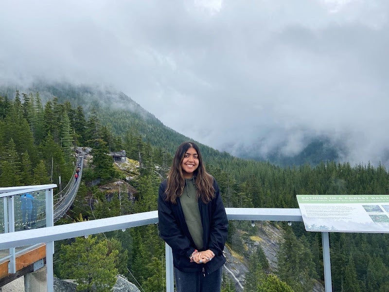 A photo of Hima standing in front of mountains.