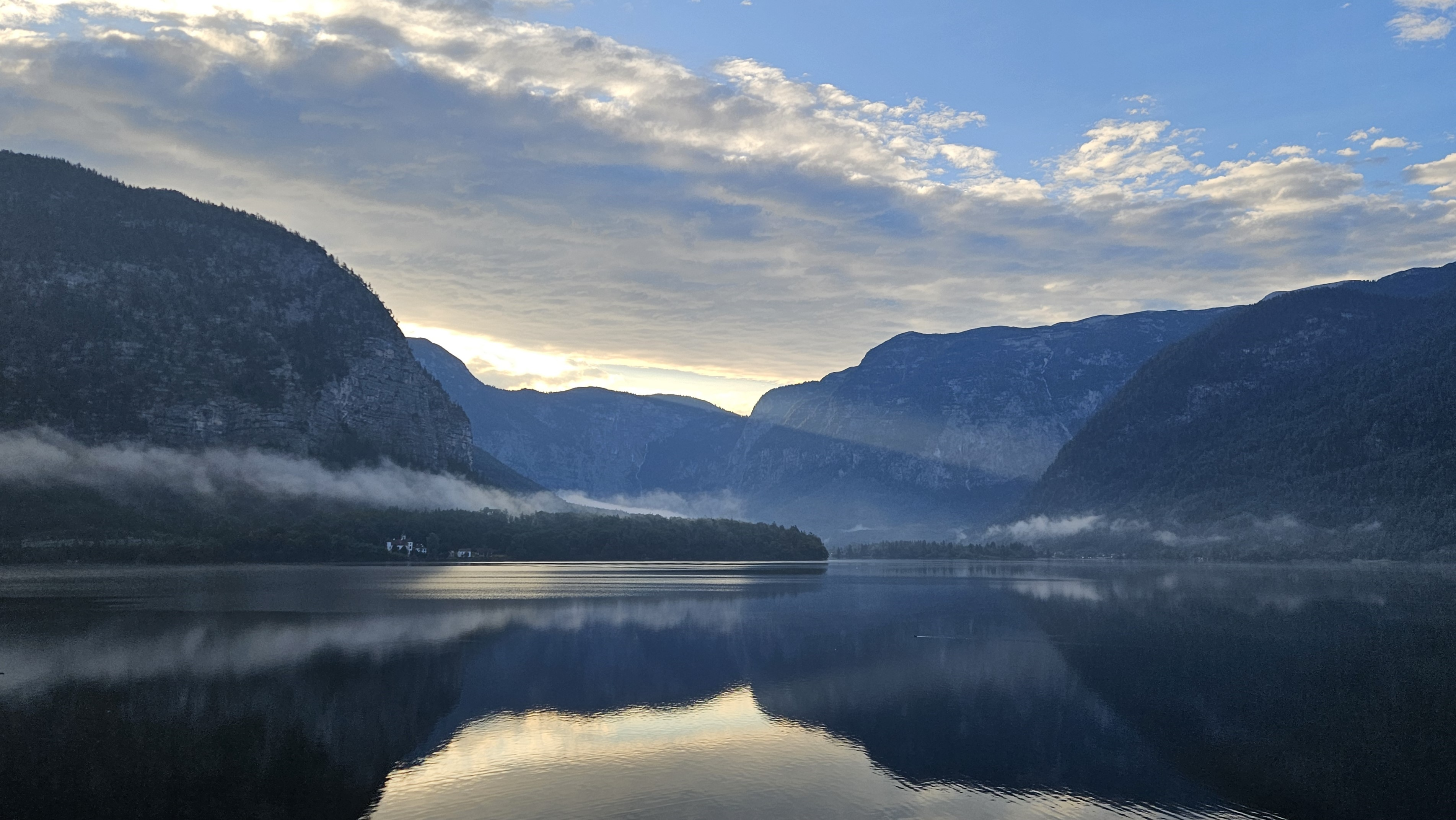 Early morning overlooking a glassy lake and a dark mountain range
