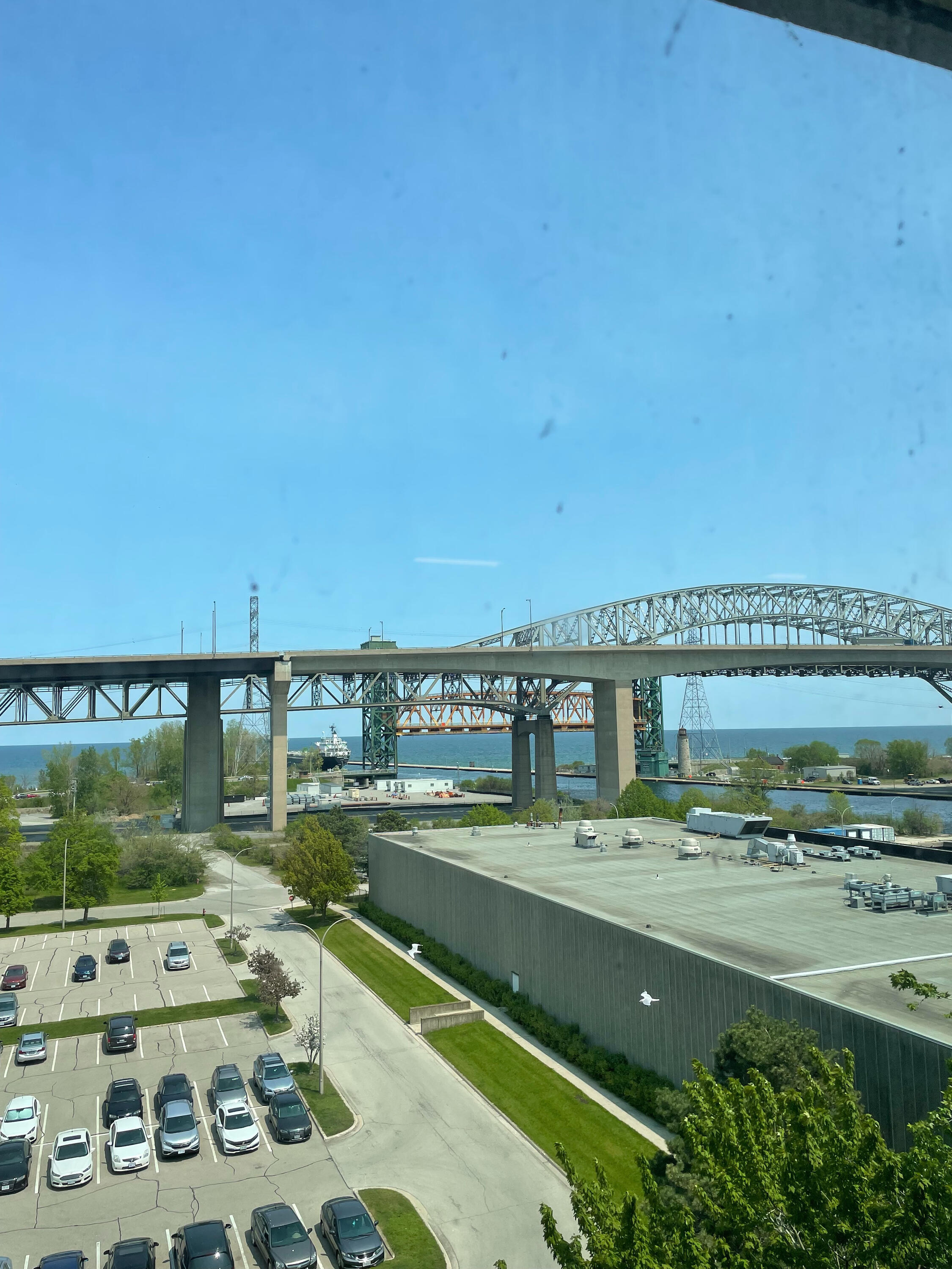 Putri's office view in Burlington overlooking a parking lot and Lake Ontario. 