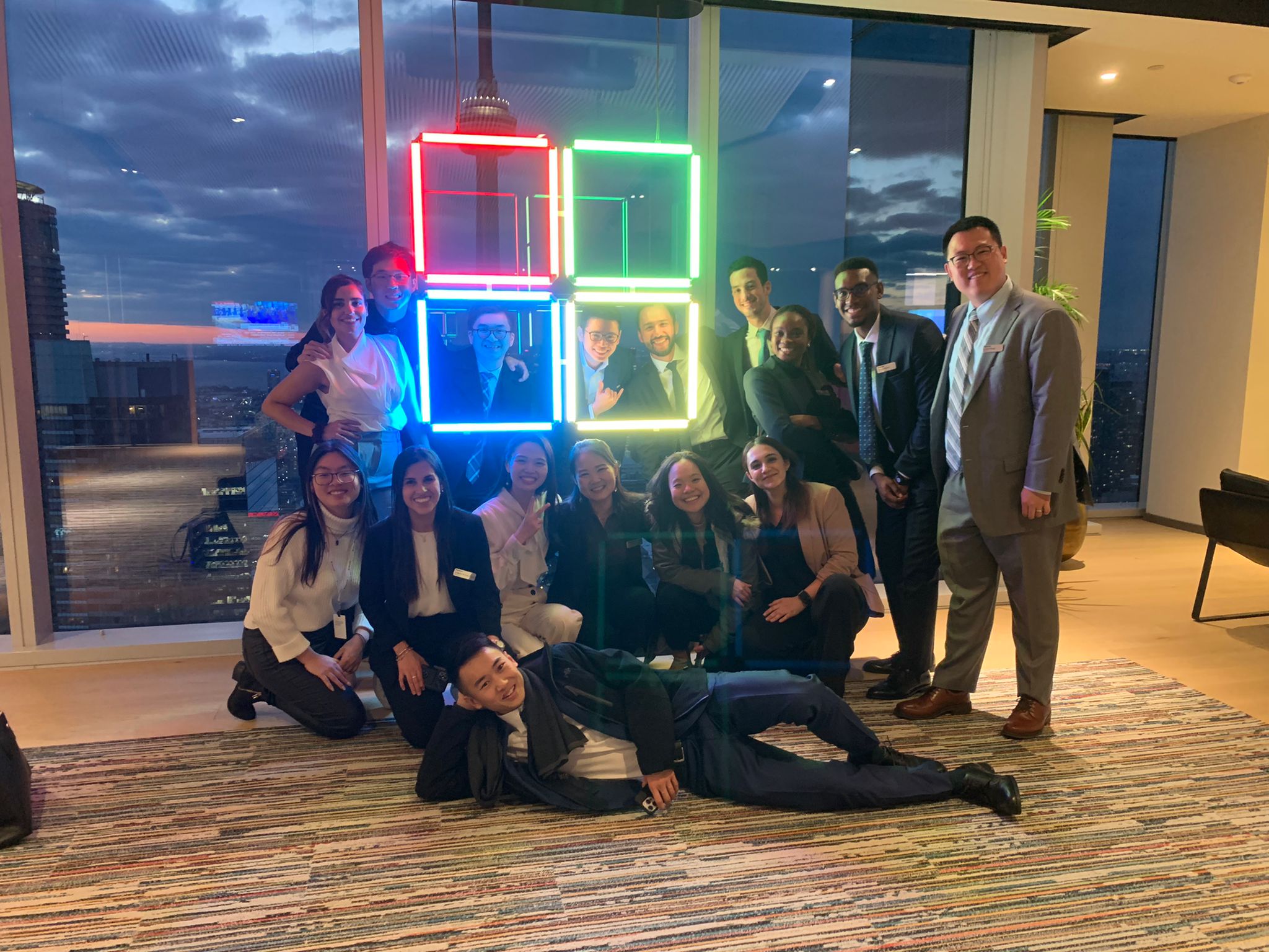 Catherine and other posing around a LED display of the Microsoft icon.