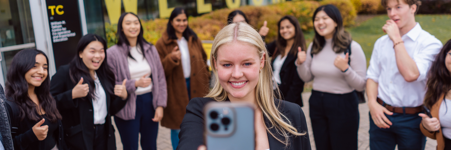 student taking selfie with a group of co-op students